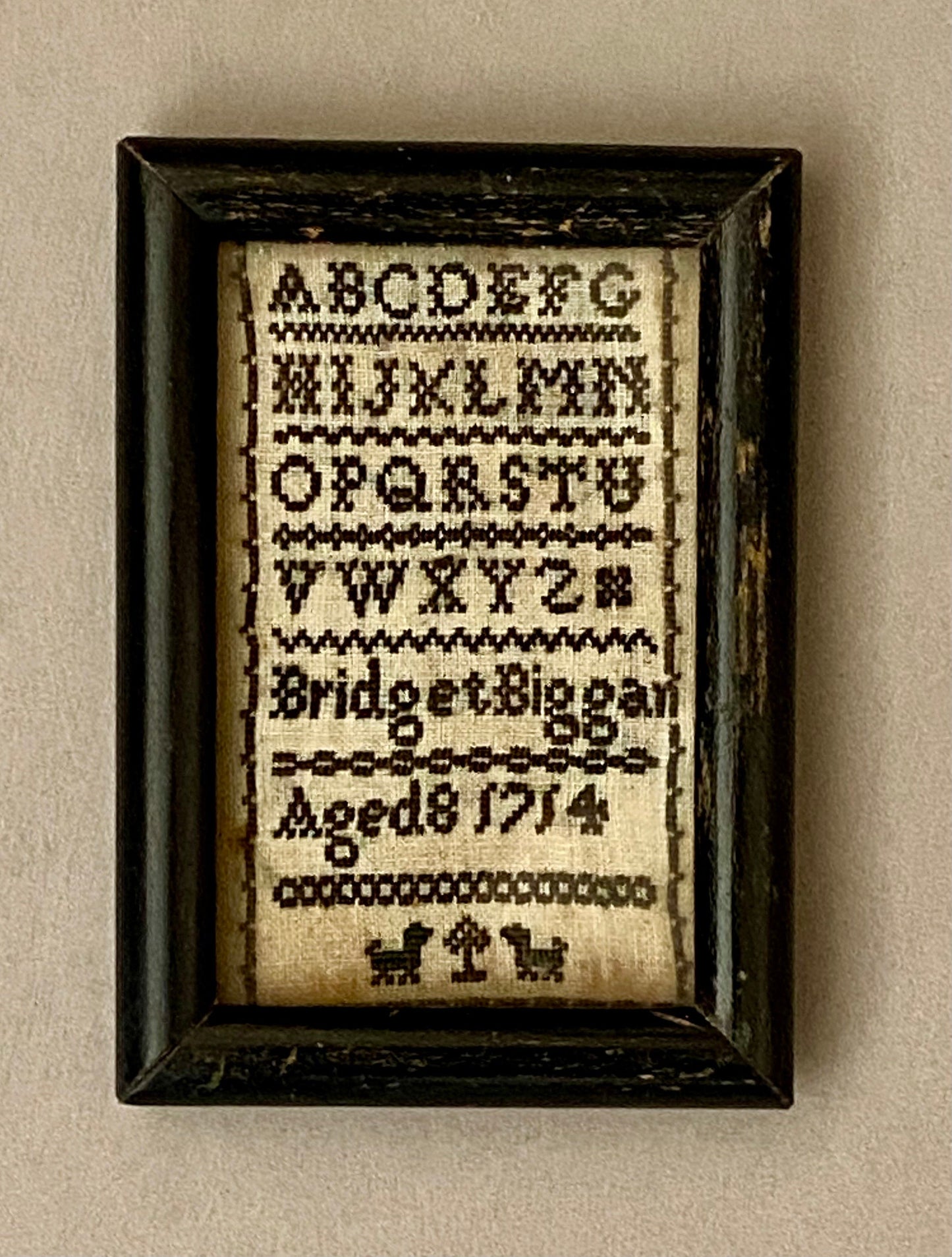 An early and very rare English Alphabet Sampler of extremely small size. Dated 1714, by Bridget Biggan. Aged 8. Size in Frame: 6 x 8.8 cm