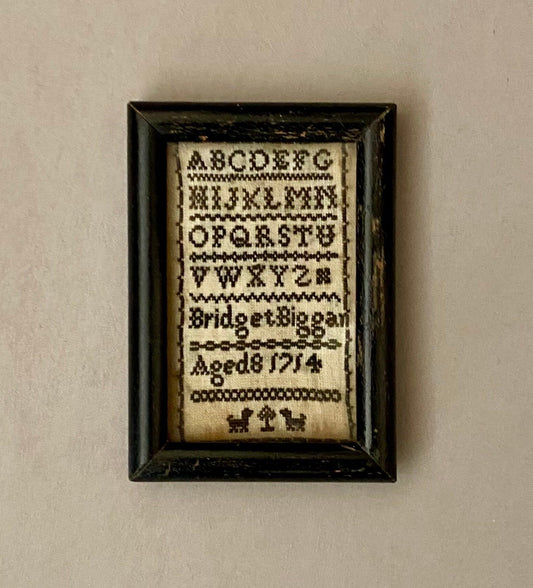 An early and very rare English Alphabet Sampler of extremely small size. Dated 1714, by Bridget Biggan. Aged 8. Size in Frame: 6 x 8.8 cm