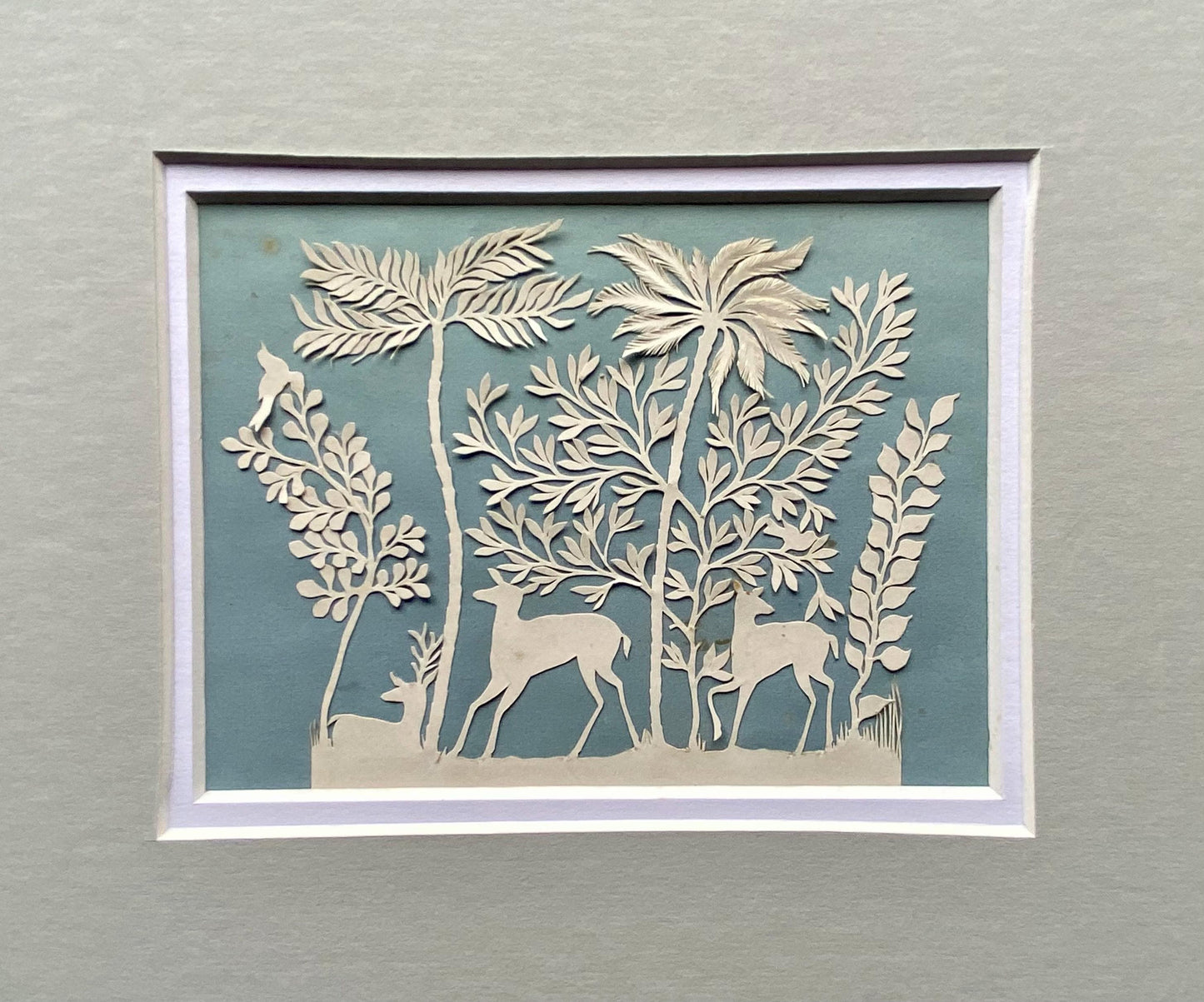 An Antique Paper Cut. Deer In a Wood. White on a Pale Blue Ground. Late Georgian, Early Victorian. Size: 9 x 12.5 cms.
