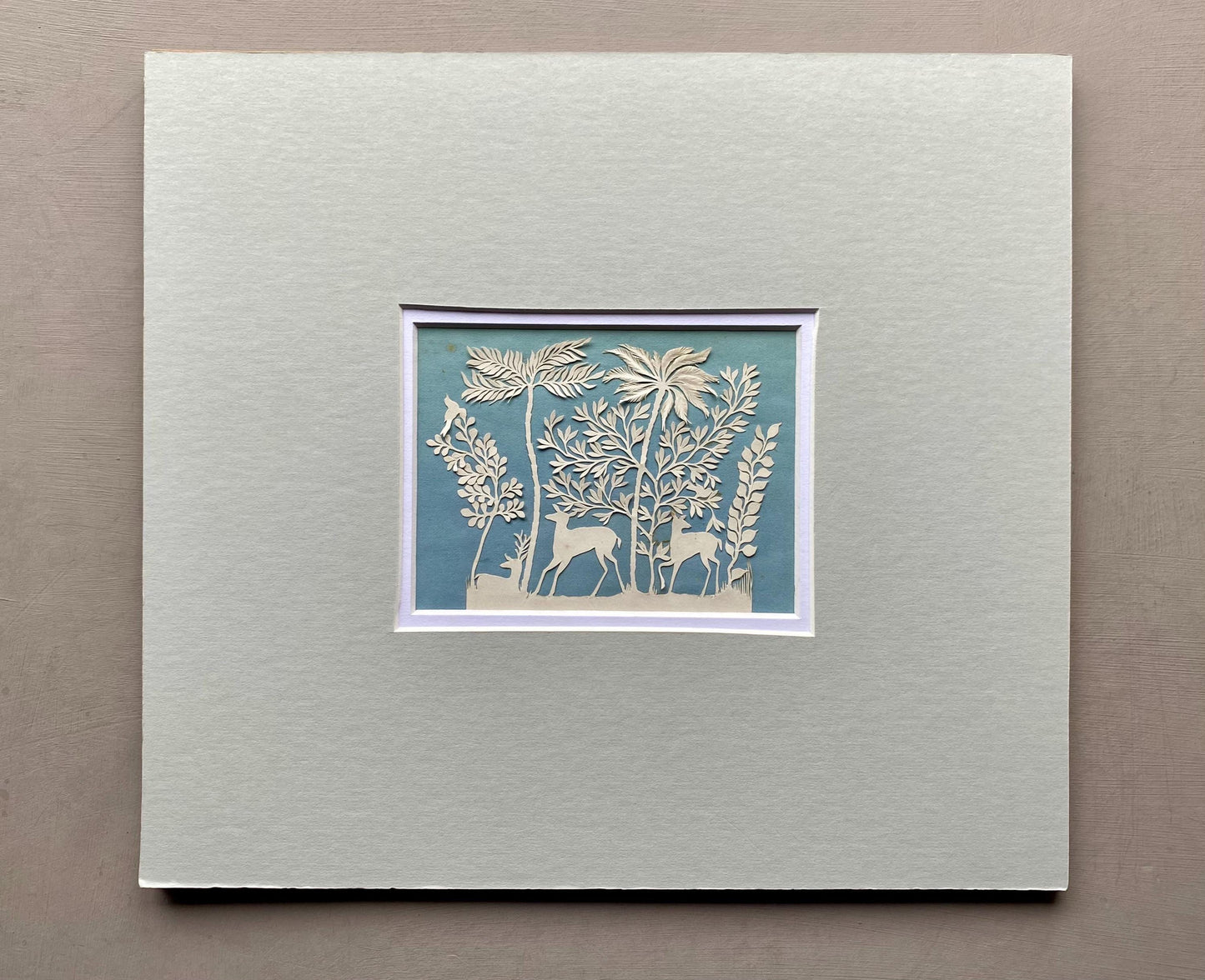 An Antique Paper Cut. Deer In a Wood. White on a Pale Blue Ground. Late Georgian, Early Victorian. Size: 9 x 12.5 cms.