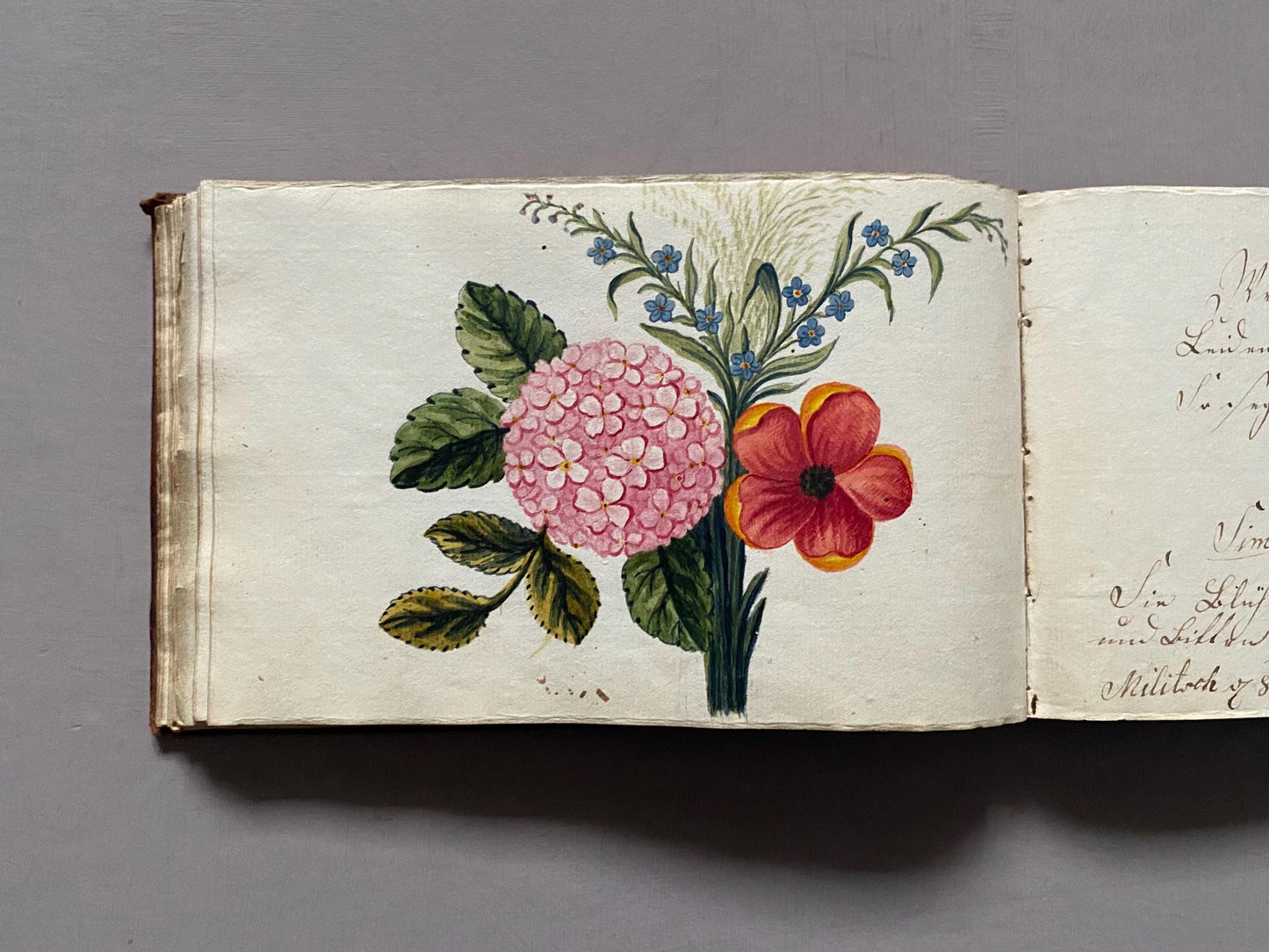A Leatherbound Autograph Book Containing 5 Watercolours and A Needlework Posy. German. Early 1800s. Size: 12 x 18.5 cms.