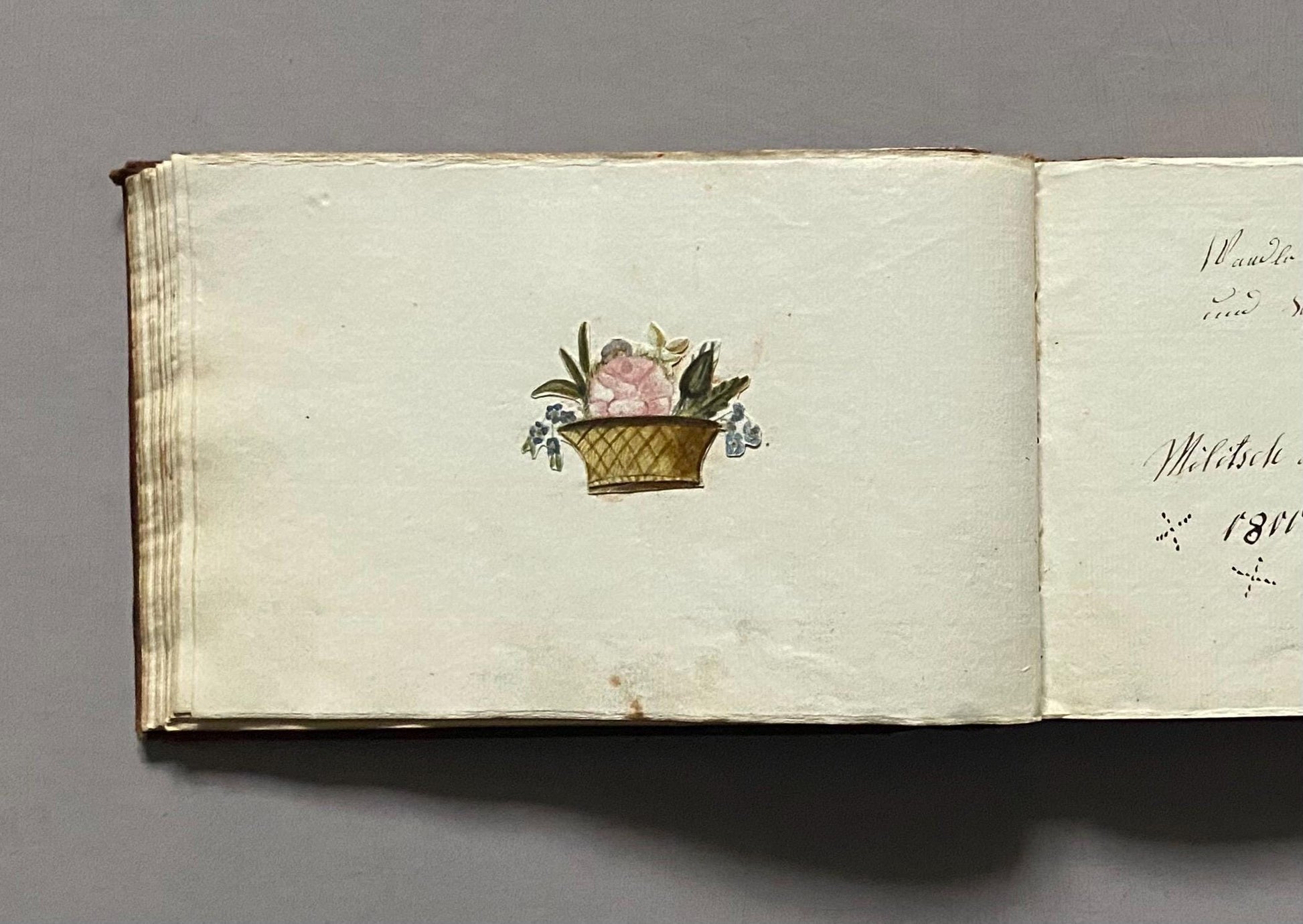 A Leatherbound Autograph Book Containing 5 Watercolours and A Needlework Posy. German. Early 1800s. Size: 12 x 18.5 cms.