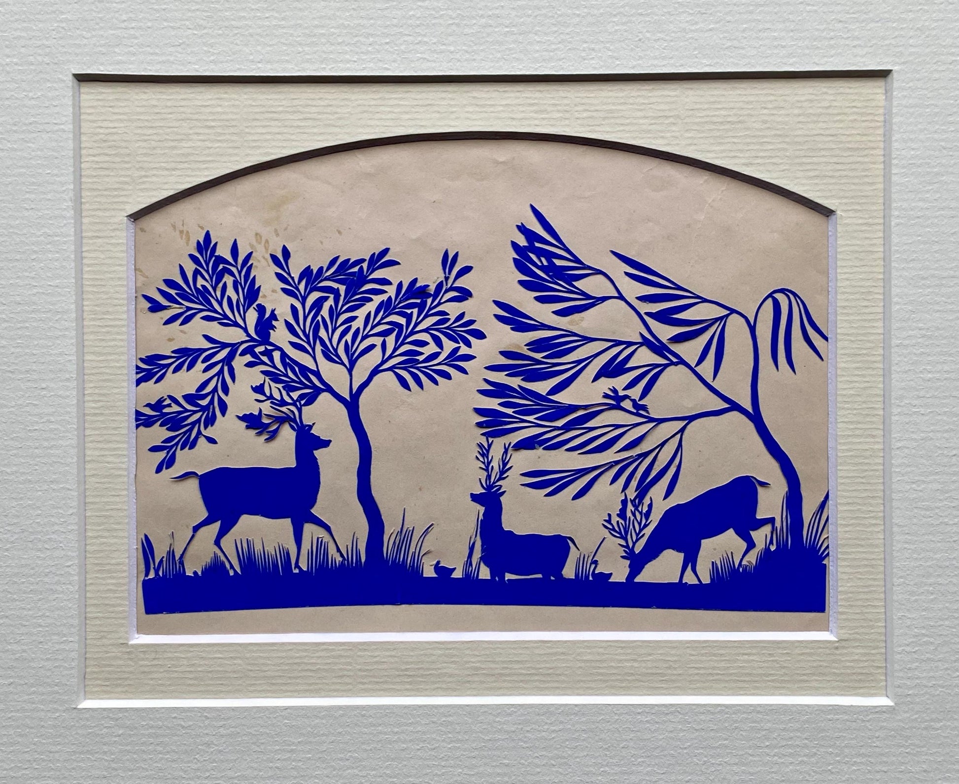 An Antique Paper Cut. Deer At A Pond. Blue on a Pinkish Cream Ground. Late Georgian, Early Victorian. Size: 12.7 x 21.5 cms.