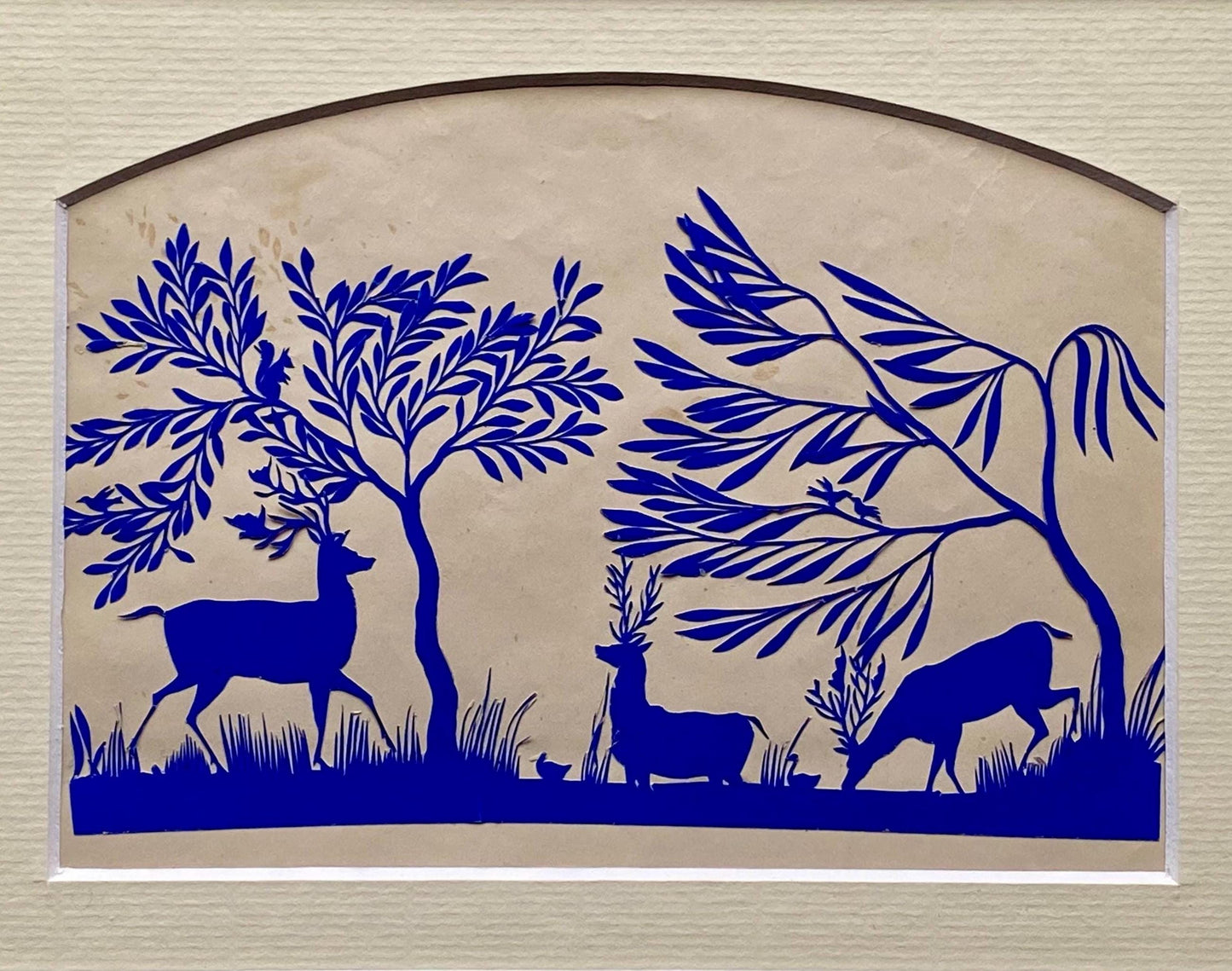 An Antique Paper Cut. Deer At A Pond. Blue on a Pinkish Cream Ground. Late Georgian, Early Victorian. Size: 12.7 x 21.5 cms.