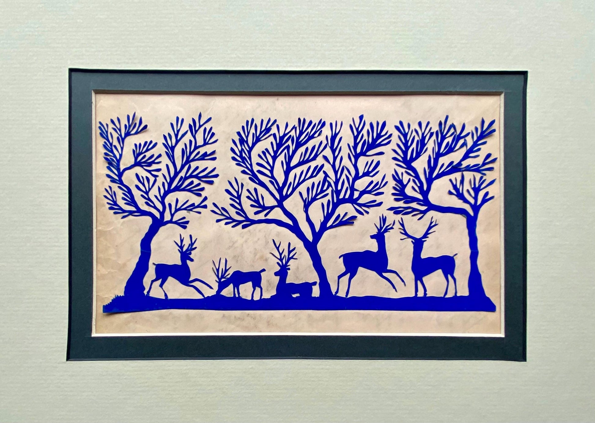 An Antique Paper Cut. Deer In a Wood. Blue on a Pale Pink Ground. Late Georgian, Early Victorian. Size: 12.7 x 21.5 cms.