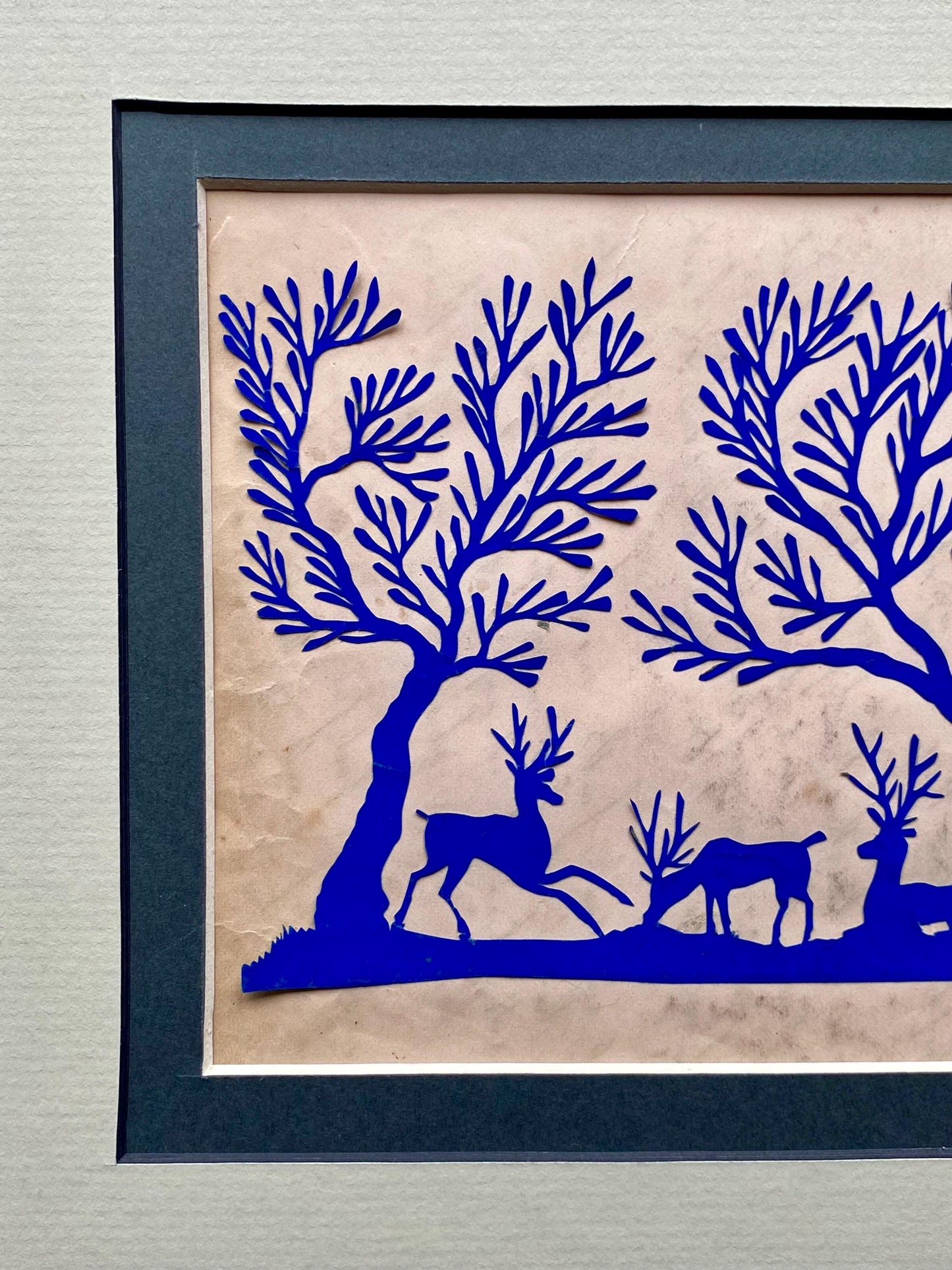 An Antique Paper Cut. Deer In a Wood. Blue on a Pale Pink Ground. Late Georgian, Early Victorian. Size: 12.7 x 21.5 cms.