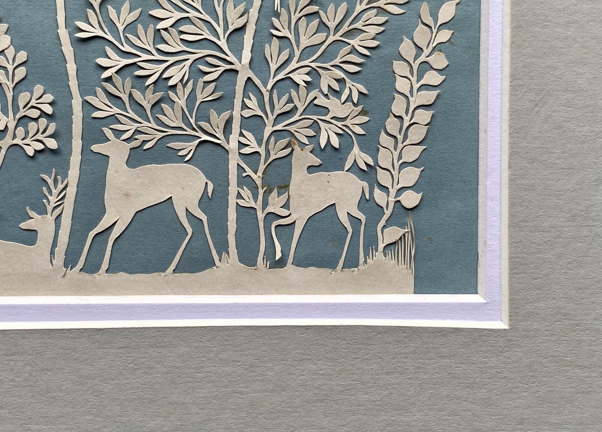 An Antique Paper Cut. Deer In a Wood. White on a Pale Blue Ground. Late Georgian, Early Victorian. Size: 9 x 12.5 cms.