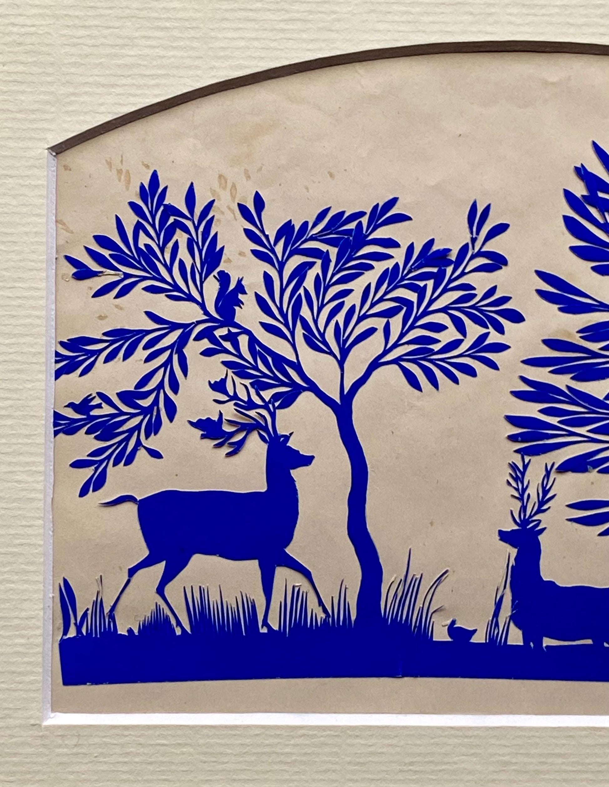 An Antique Paper Cut. Deer At A Pond. Blue on a Pinkish Cream Ground. Late Georgian, Early Victorian. Size: 12.7 x 21.5 cms.