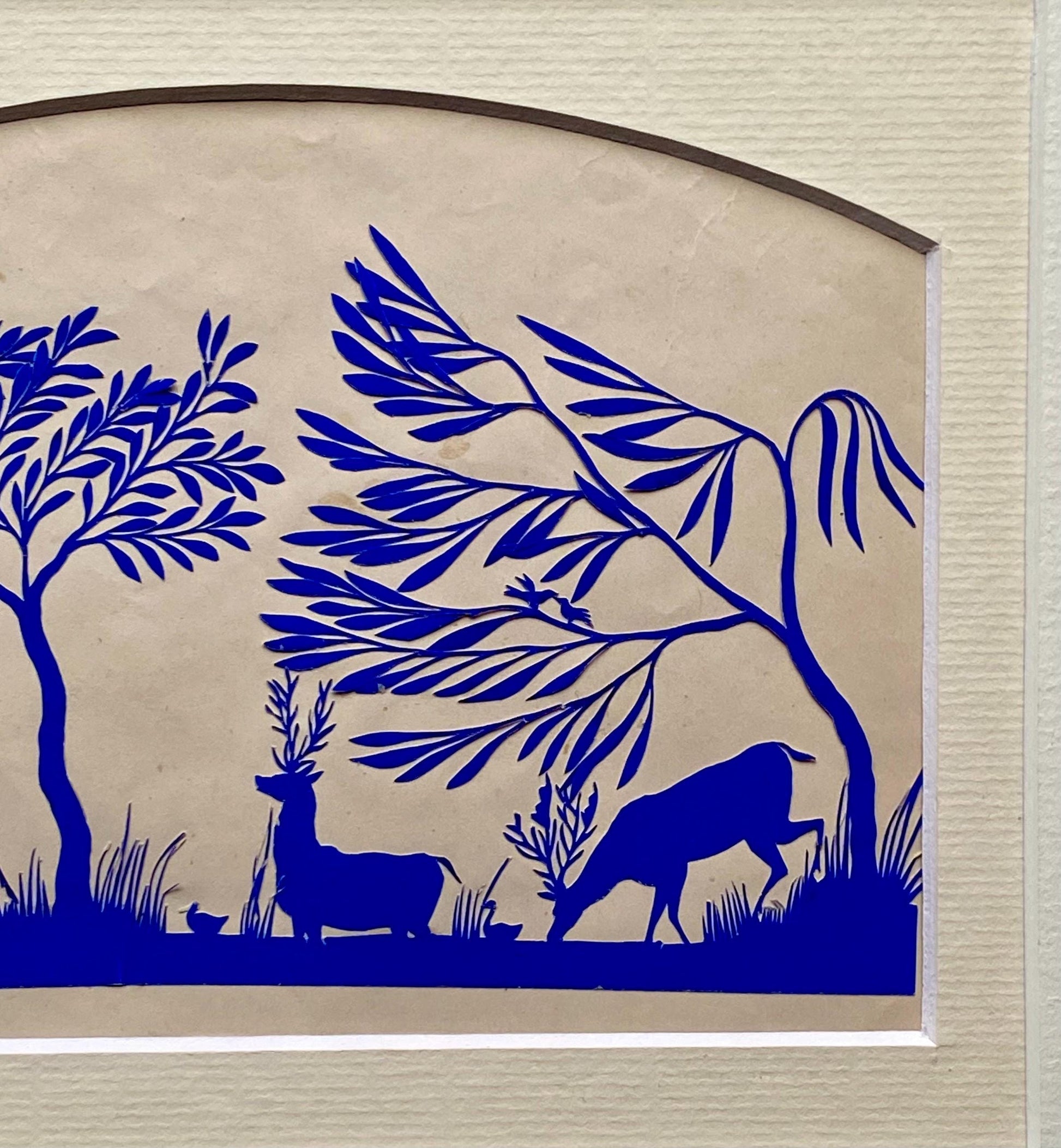 An Antique Paper Cut. Deer At A Pond. Blue on a Pinkish Cream Ground. Late Georgian, Early Victorian. Size: 12.7 x 21.5 cms.