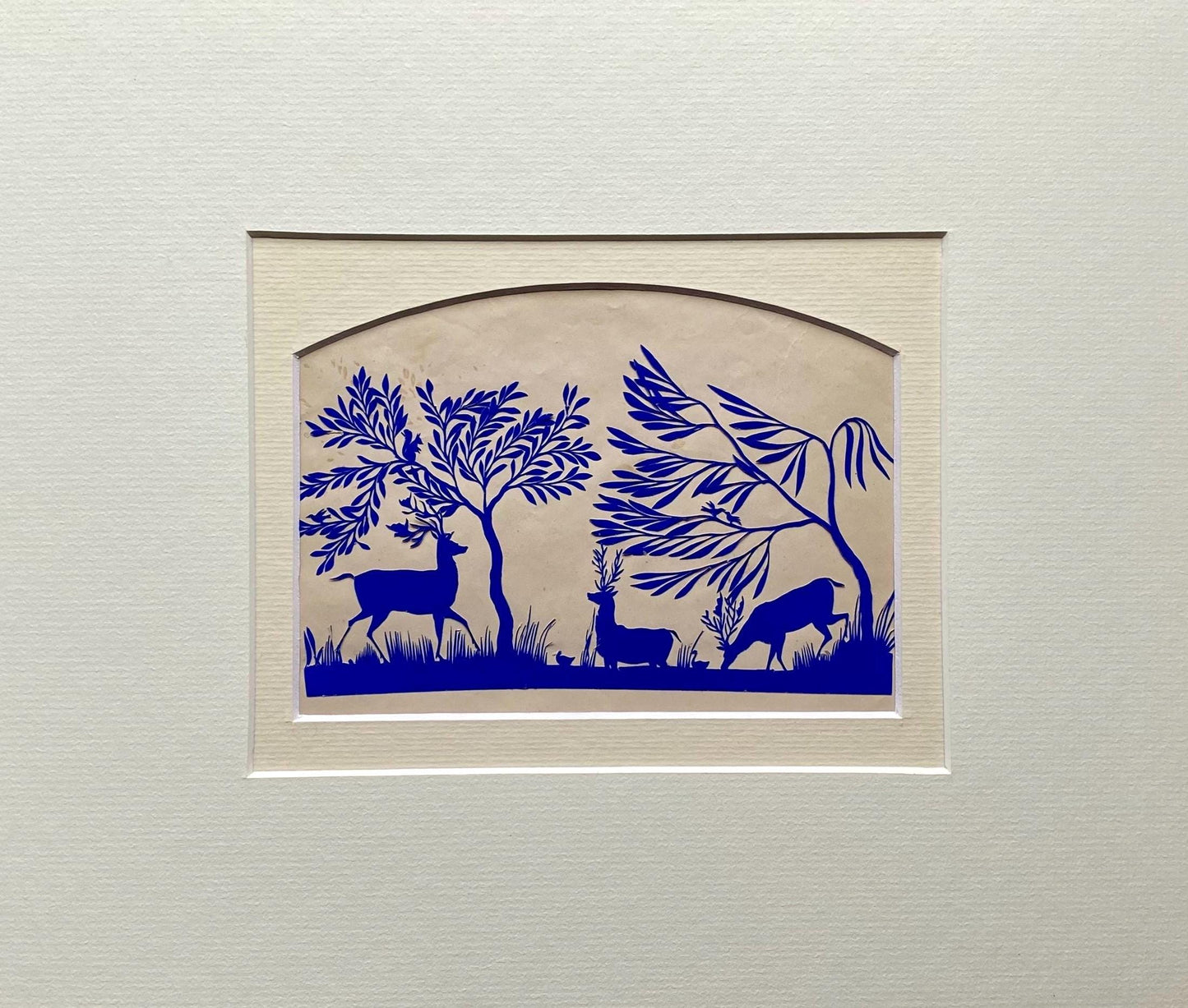 An Antique Paper Cut. Deer At A Pond. Blue on a Pinkish Cream Ground. Late Georgian, Early Victorian. Size: 12.7 x 21.5 cms.