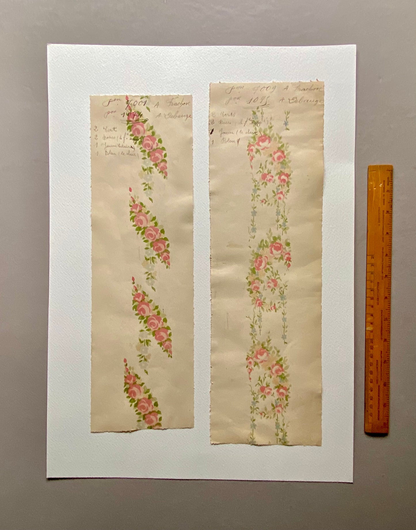 May include: Two samples of vintage wallpaper with floral patterns. The left sample features a pink and green floral design with the text "From 2001 A Fraser for 10/6 + a Change". The right sample features a pink and blue floral design with the text "From 2009 A Fraser for 10/6 + a Change".