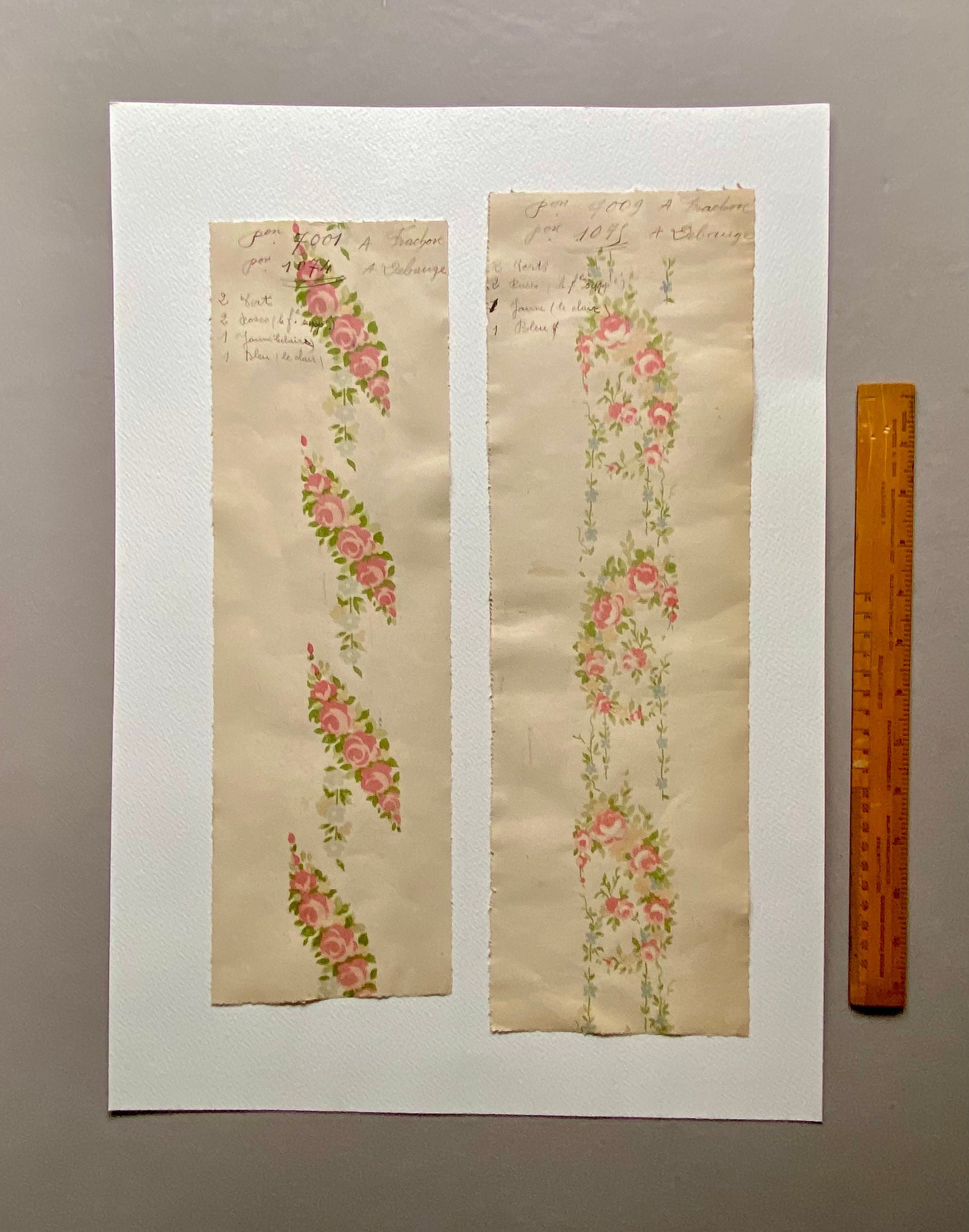May include: Two samples of vintage wallpaper with floral patterns. The left sample features a pink and green floral design with the text "From 2001 A Fraser for 10/6 + a Change". The right sample features a pink and blue floral design with the text "From 2009 A Fraser for 10/6 + a Change".