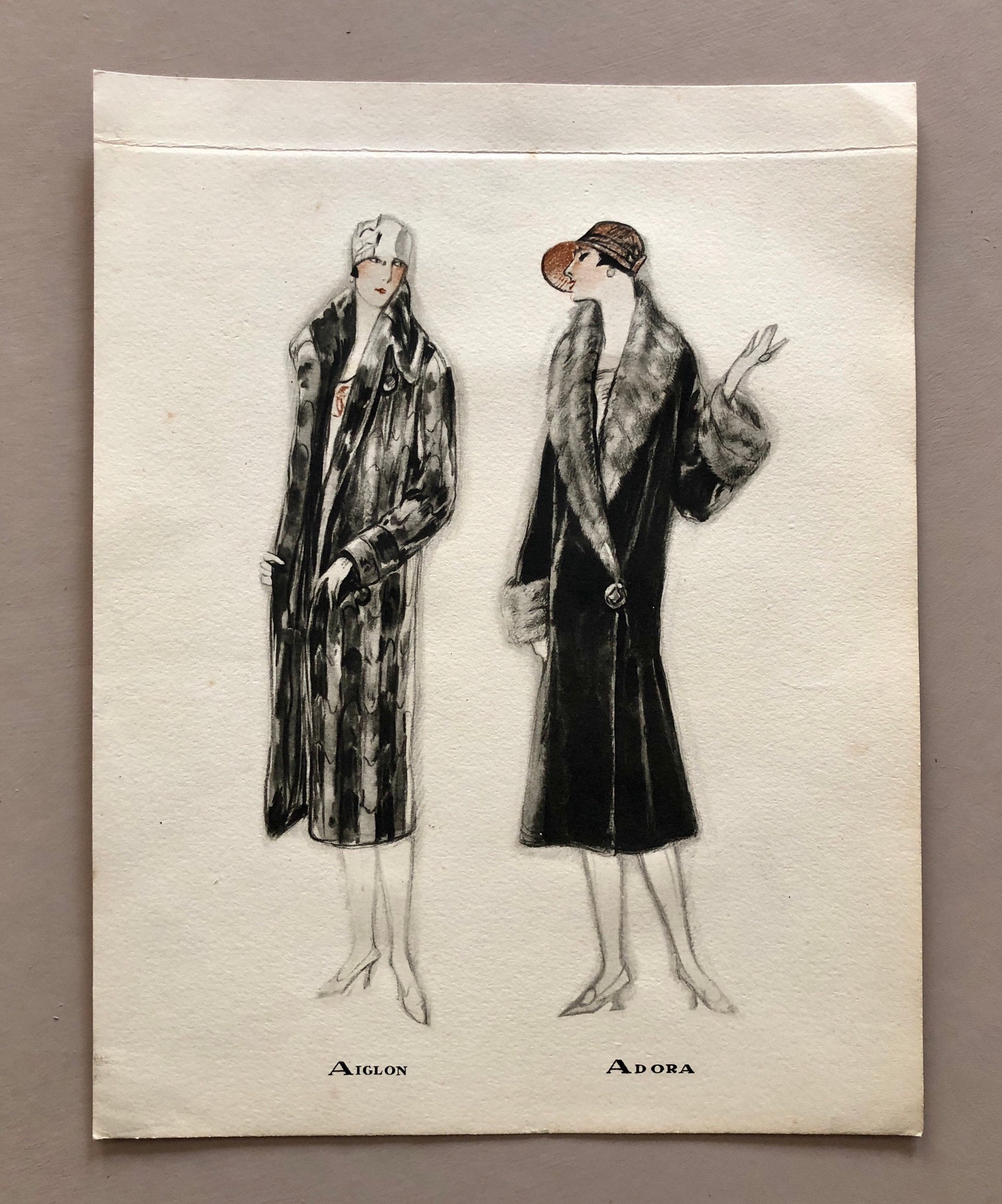 May include: A black and white illustration of two women wearing fur coats. The woman on the left is wearing a white hat and the woman on the right is wearing a brown hat. The text "AIGLON" and "ADORA" is printed below the women.