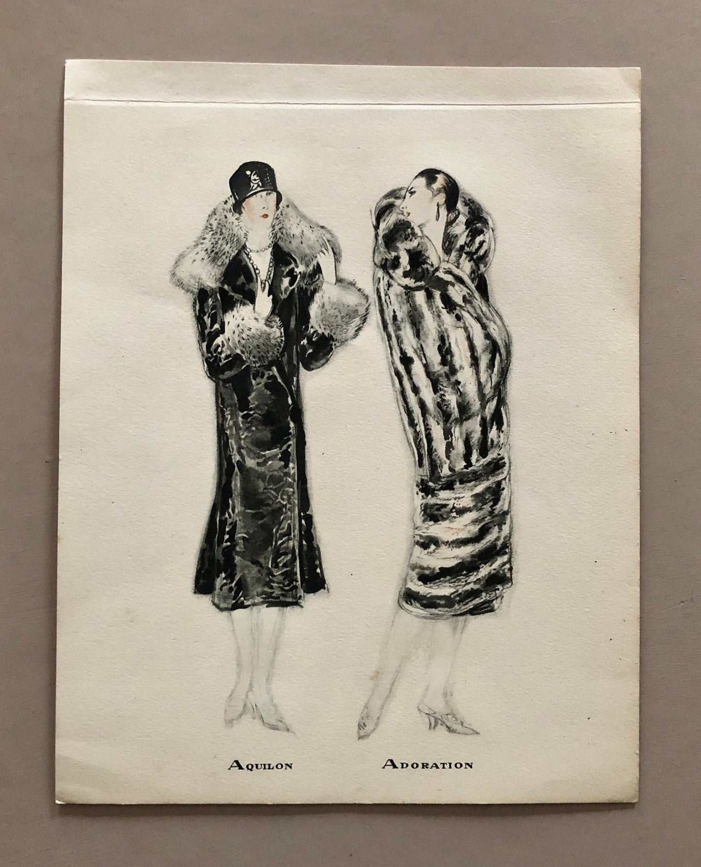 May include: Black and white illustration of two women wearing fur coats. The woman on the left is wearing a hat and the woman on the right is wearing a fur coat with a striped pattern. The text "Aquilon" and "Adoration" is written below the women.